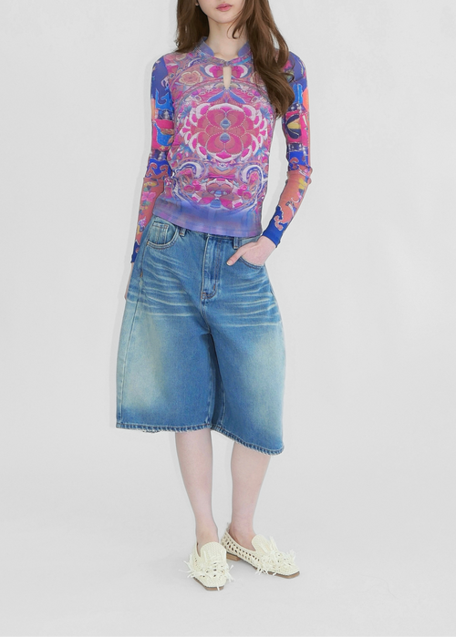 A model wearing Chinese style print in blue and pink mesh top with madarin collar and chinese knot fastening and denim shorts