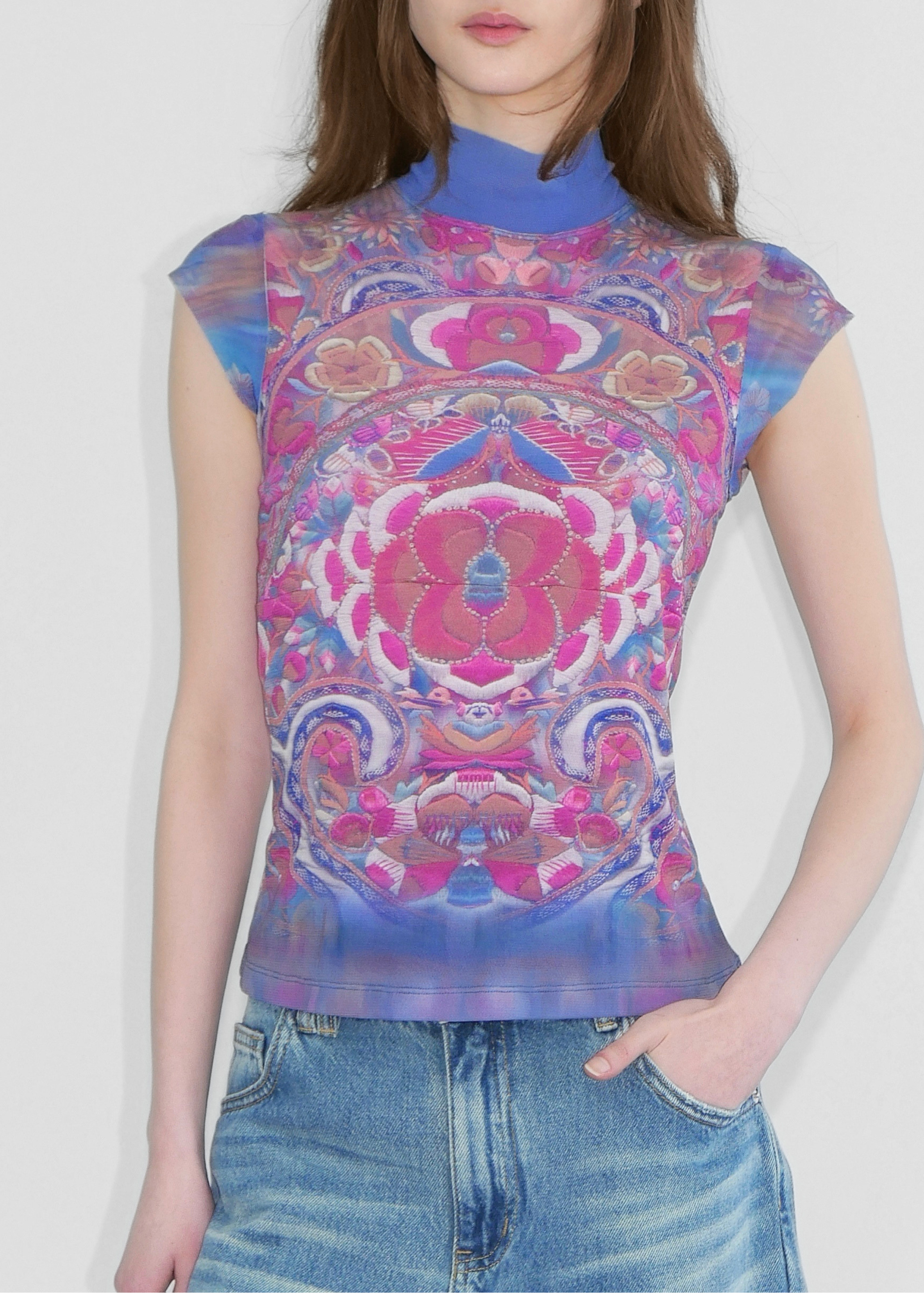 Model wearing a cap sleeve tank top with turtle neck in Chinese style blue and pink print