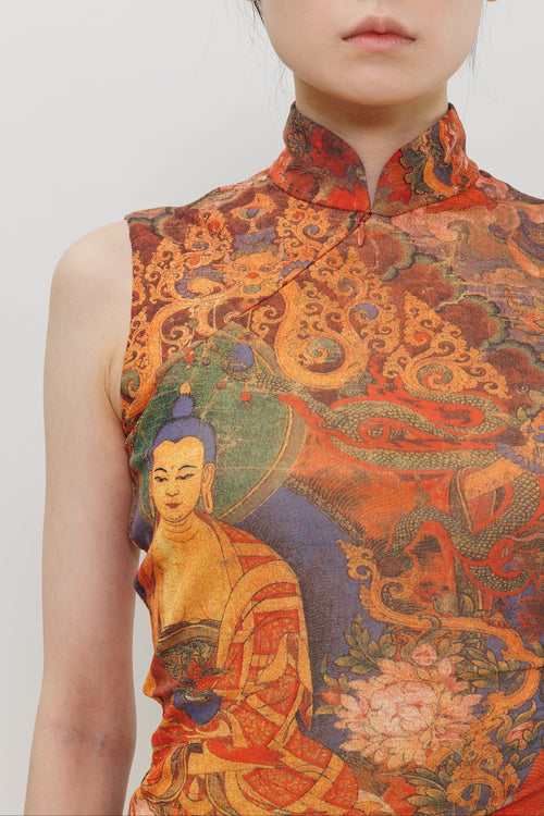A close-up of a model wearing a sleeveless high-neck cheongsam-style top with an intricate, colorful print featuring a Buddha figure and swirling cloud-like patterns in orange, red, blue, green, and gold tones.