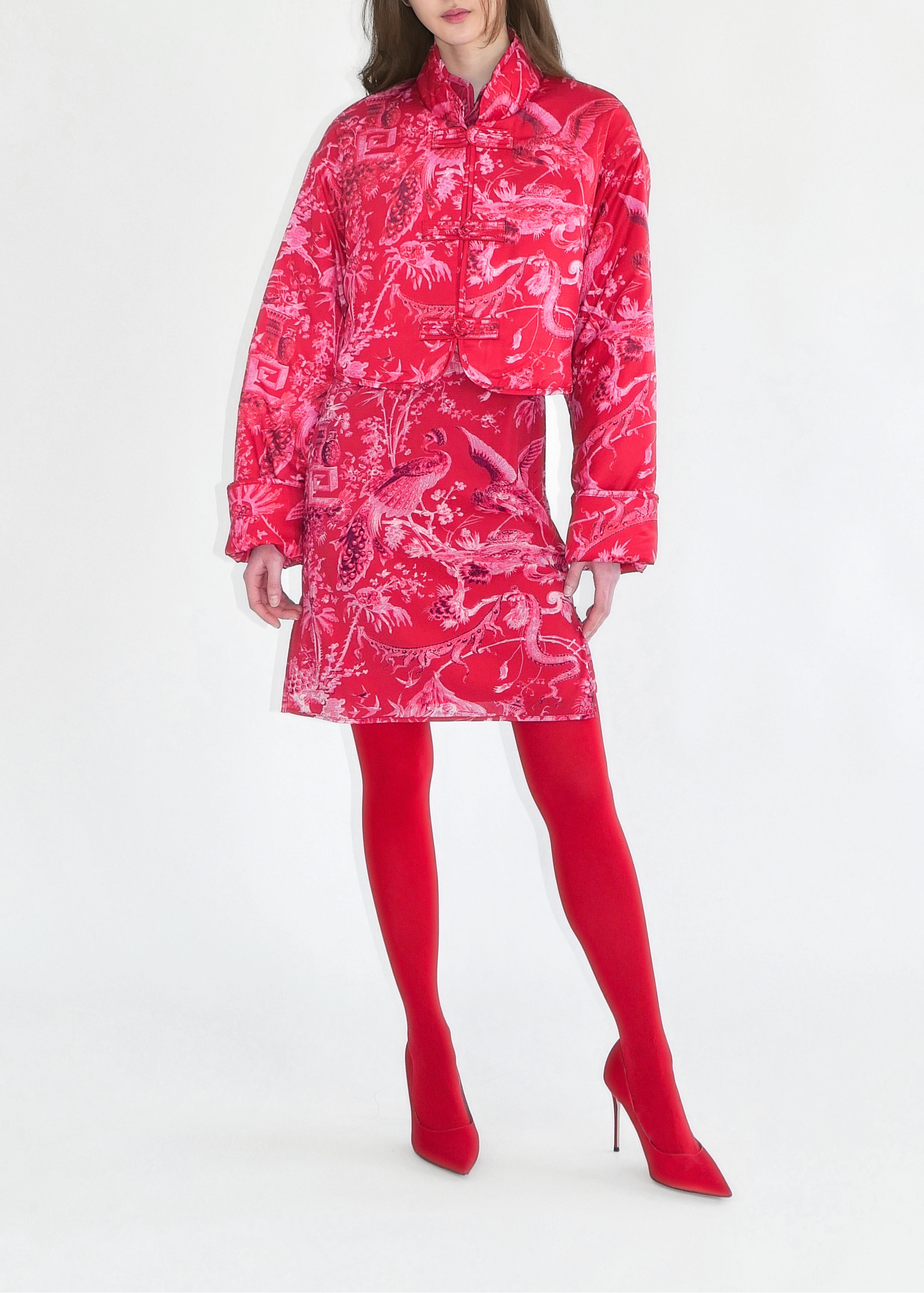 Woman wearing a red patterned raincoat on a white background