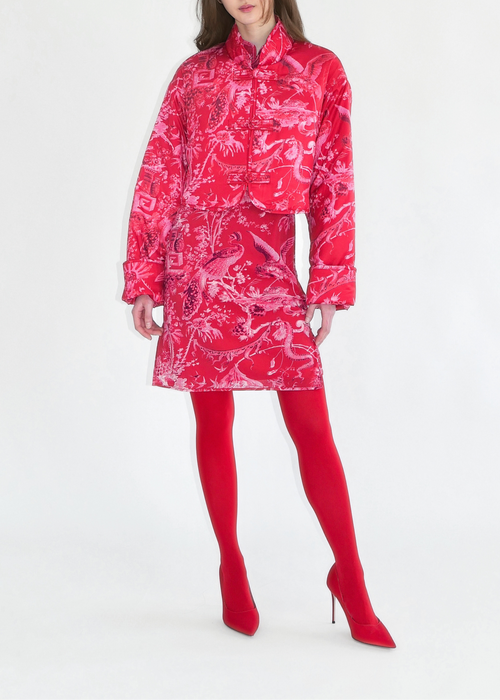 Woman wearing a red patterned raincoat on a white background
