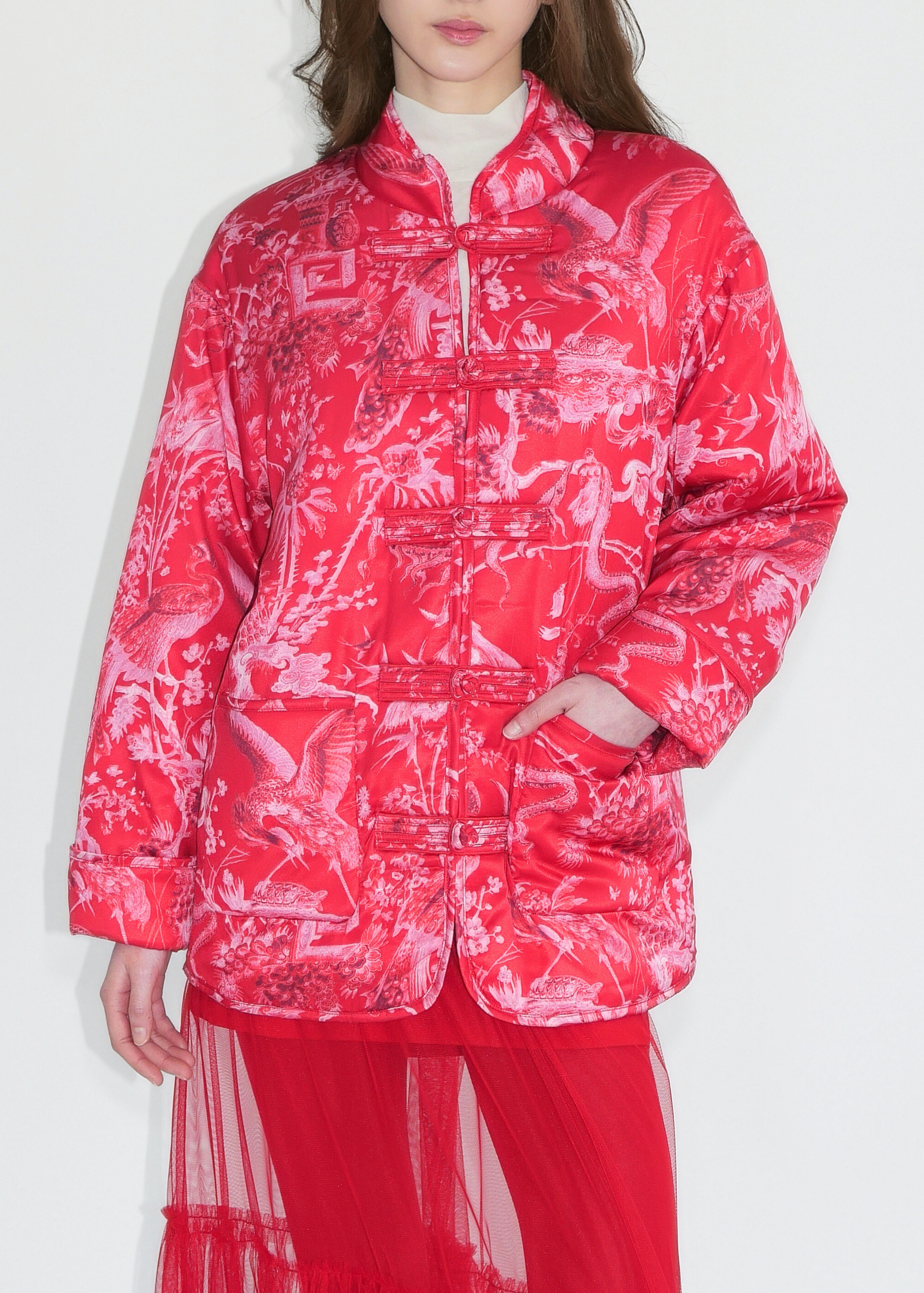 Person wearing a red and white patterned jacket on a white background