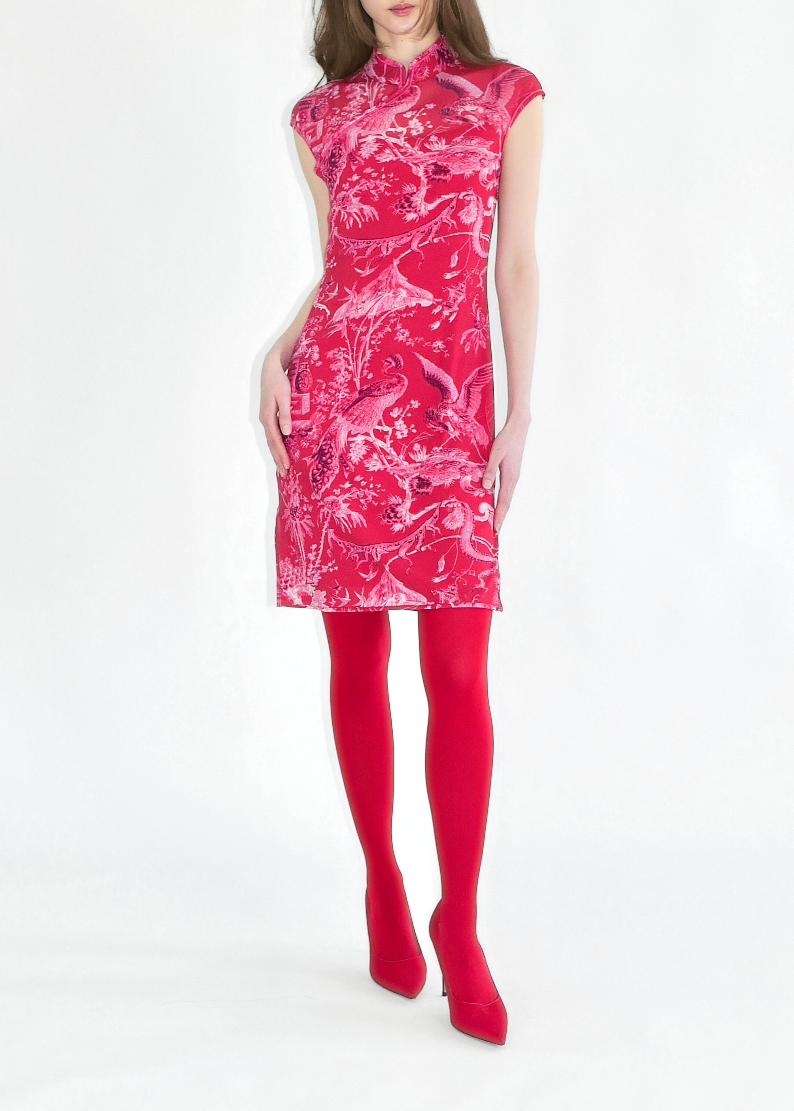 Woman wearing a pink dress with white floral pattern on a white background