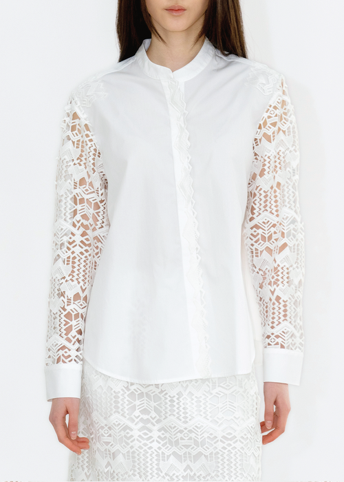 A woman wearing a white Chinese collar shirt with deer lace on the sleeves.
