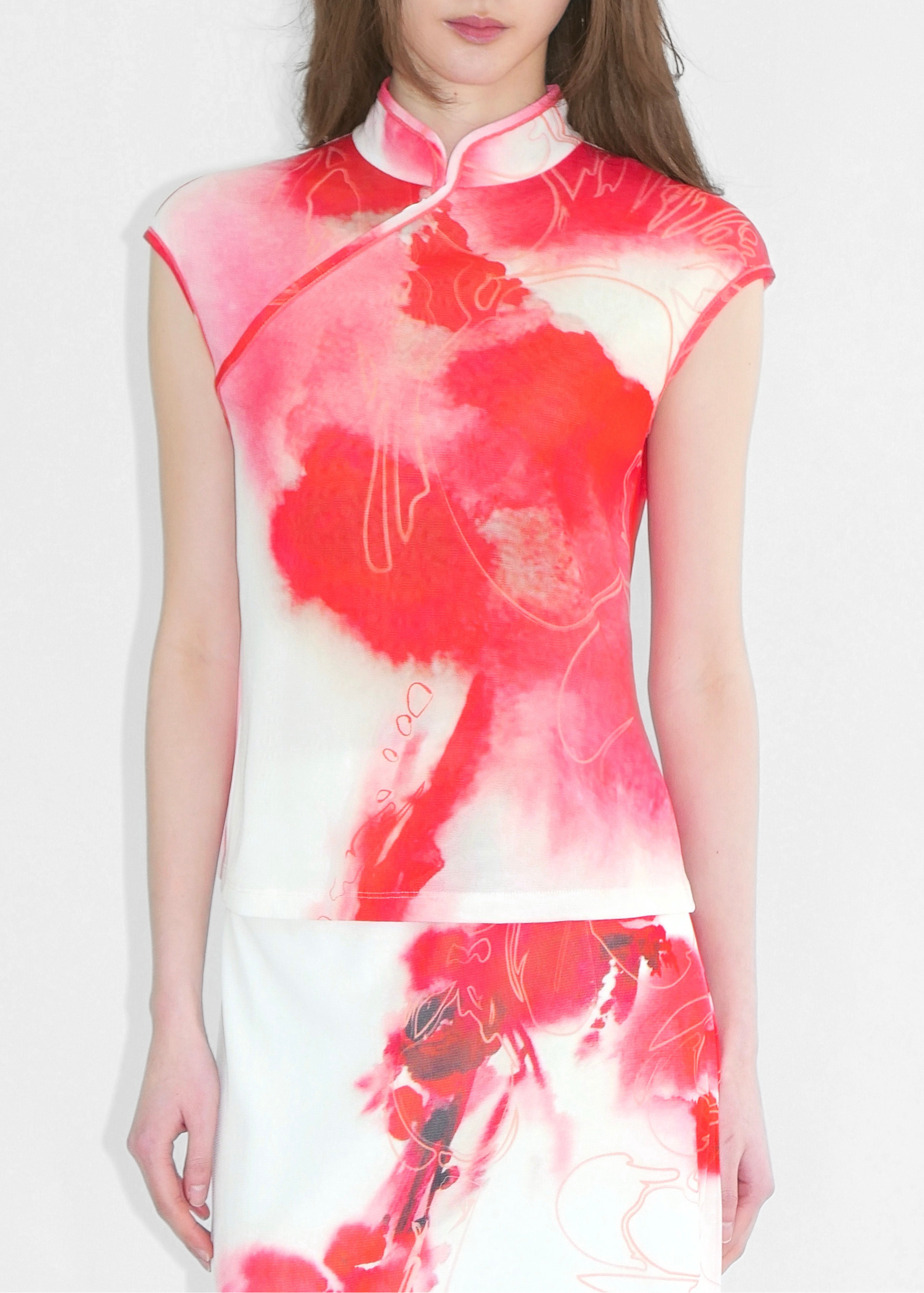 Woman wearing a red and white floral dress on a plain background