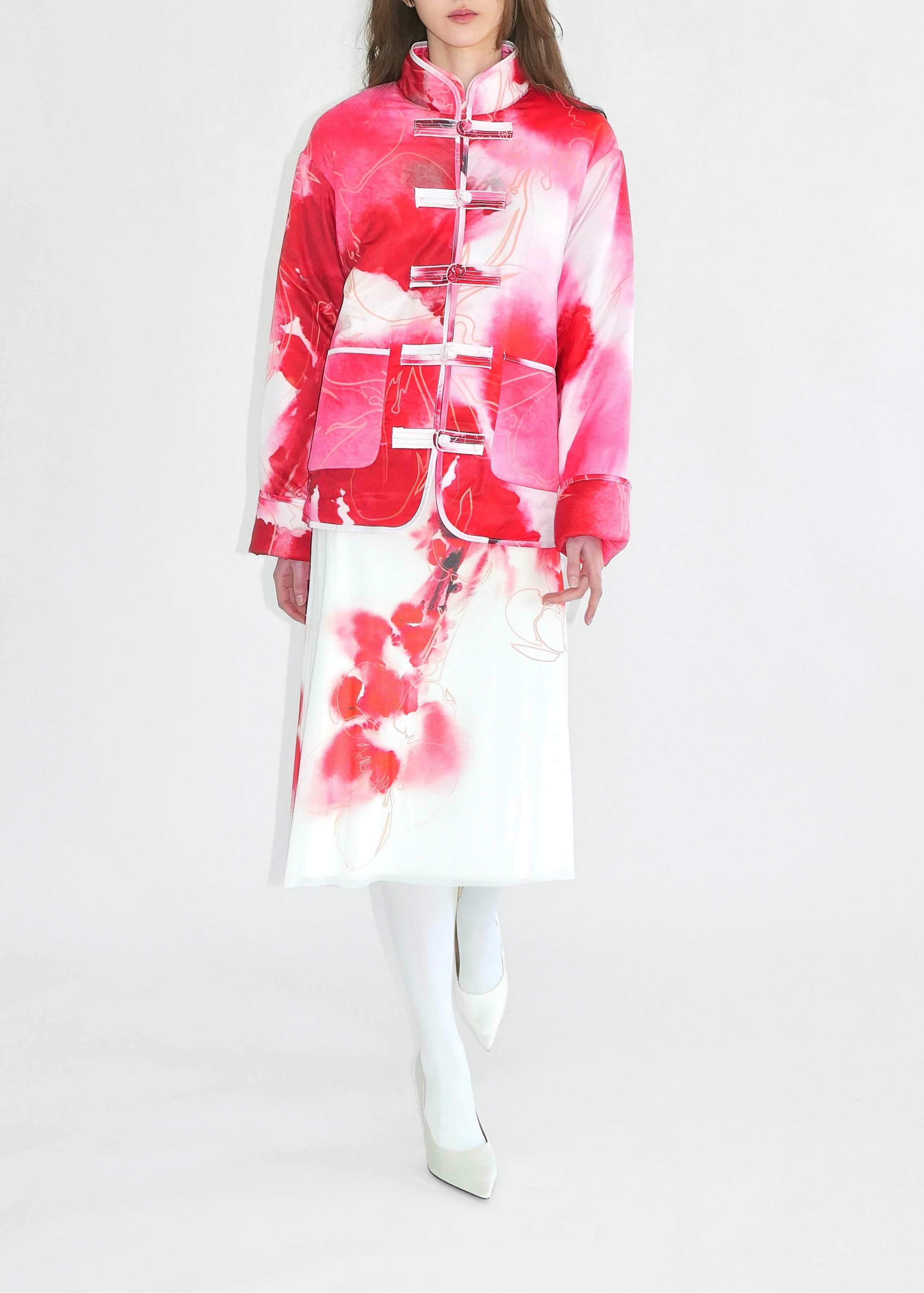 Woman wearing a red and white floral dress on a white background