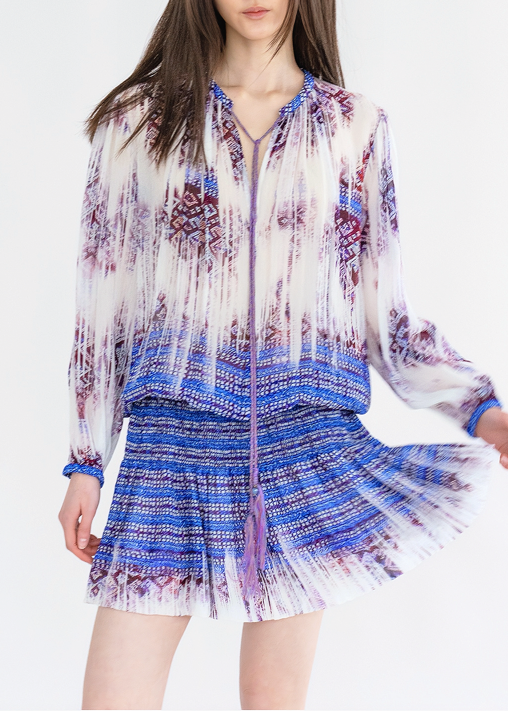 A woman wearing a multicolored crinkle viscose dress with a faded Li brocade print, featuring long sleeves and a V-neck.