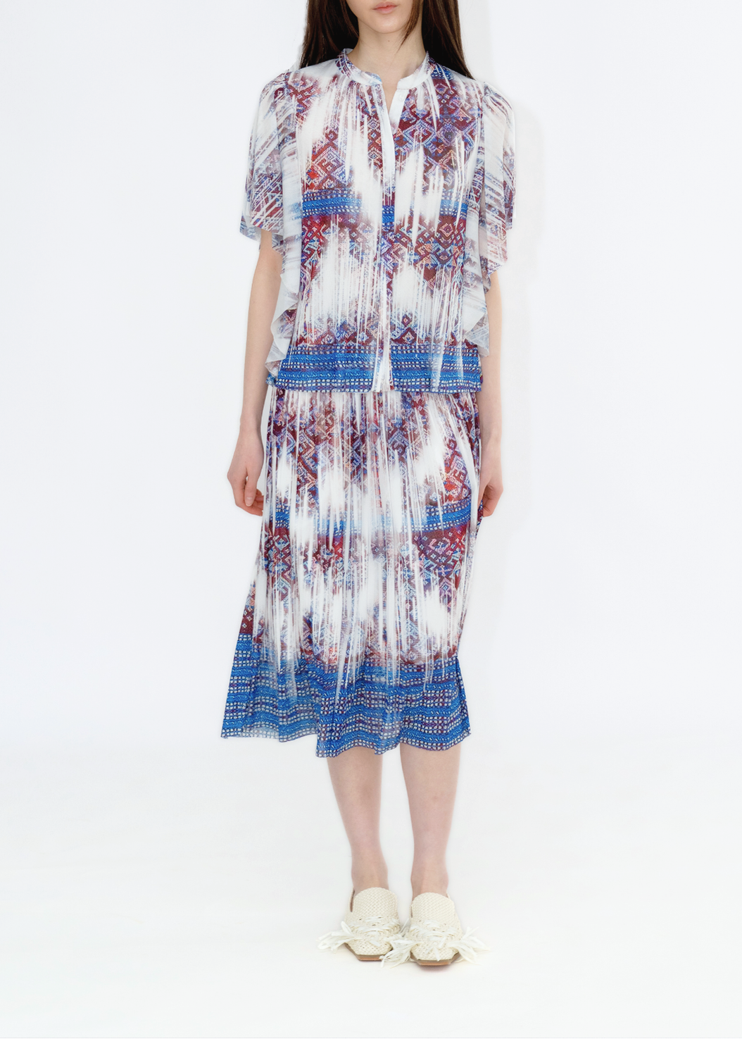 A model wearing a midi-length skirt with a faded Li brocade print in a multicolor pattern.