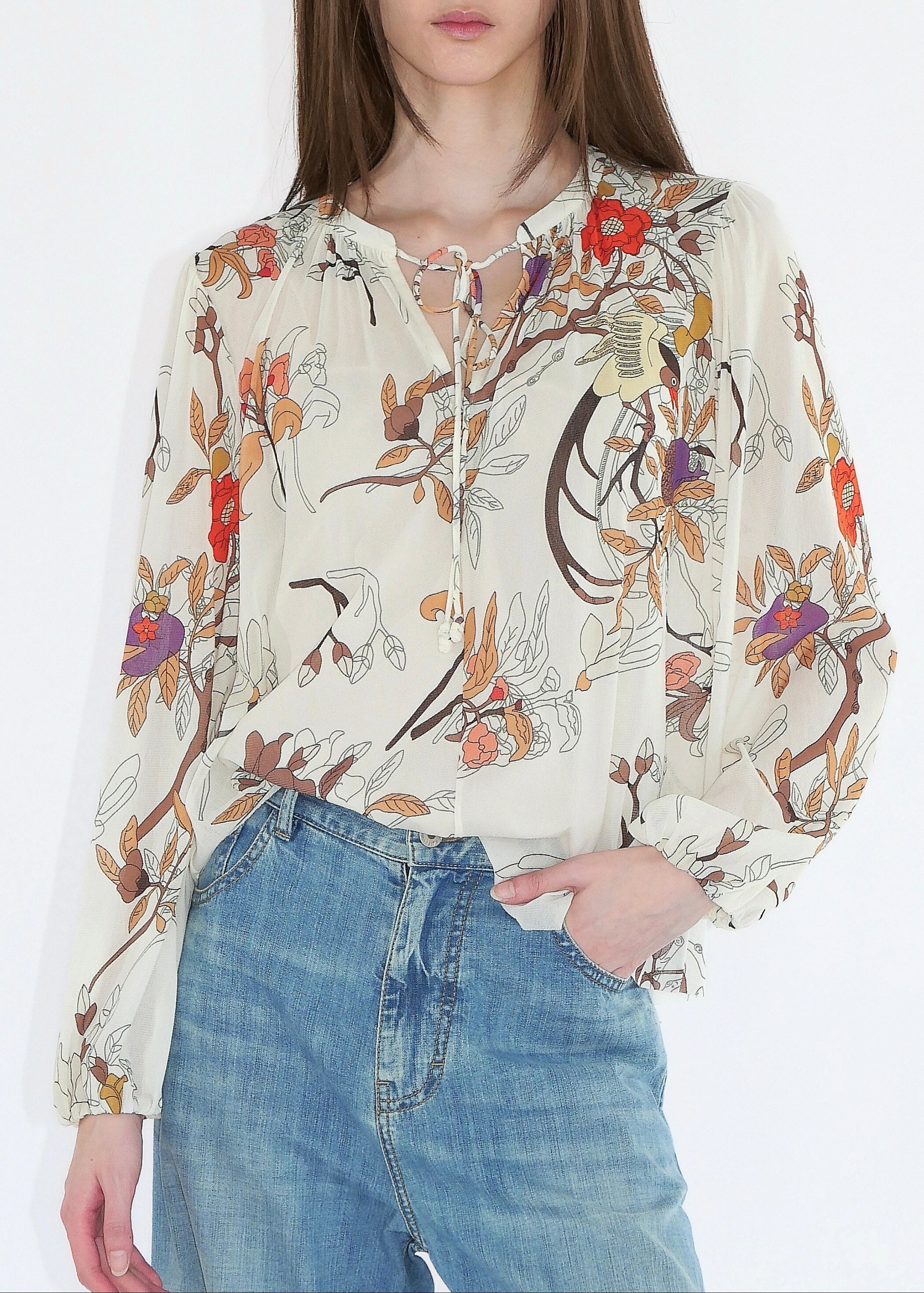 Woman wearing a floral blouse and jeans on a white background