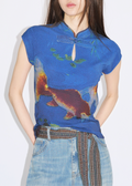 A woman wearing a blue cheongsam top with a floral pattern and a keyhole neckline.