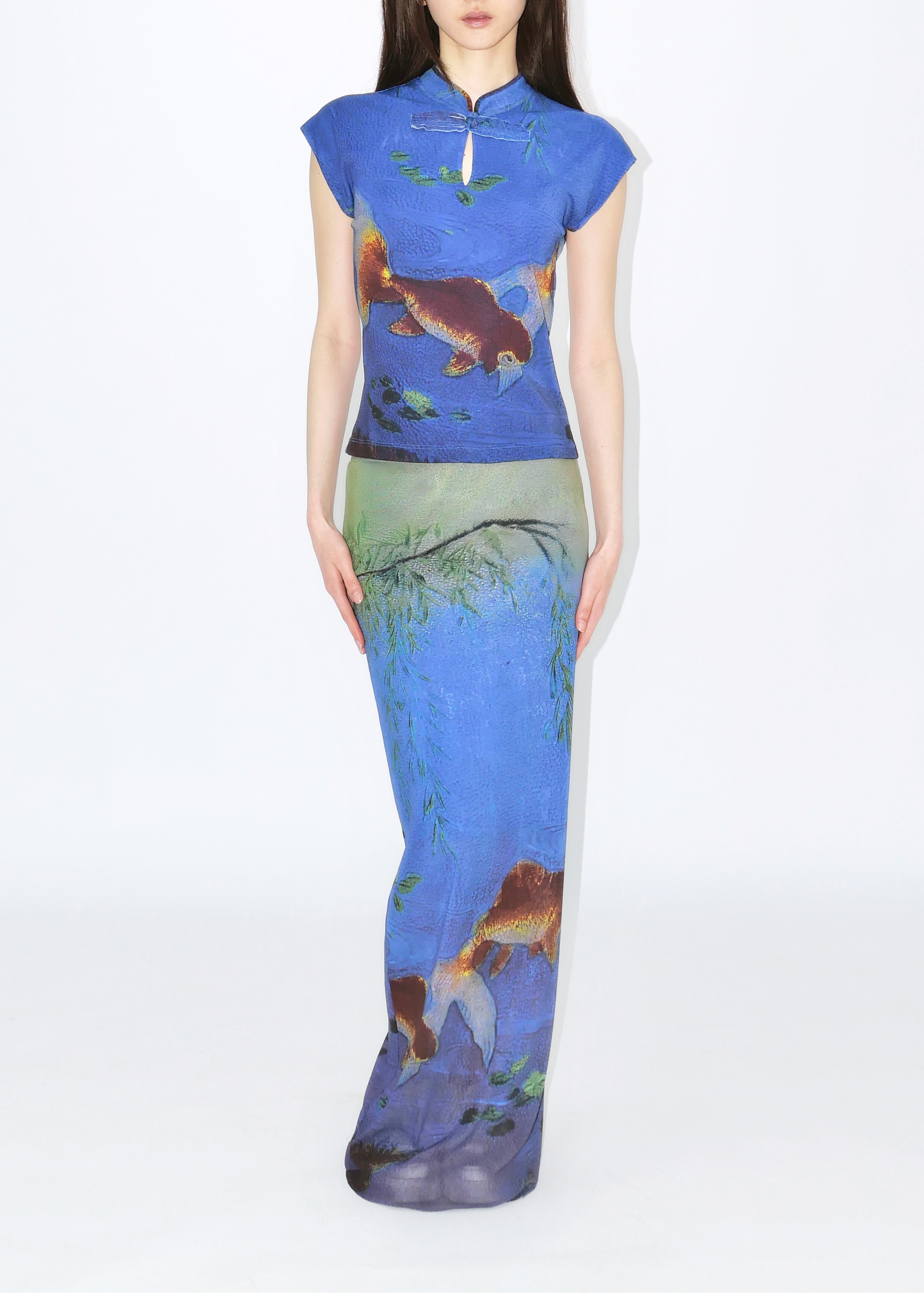 A long skirt with a netting design featuring goldfish and a landscape in blue tones.