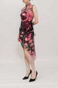 A model wearing a sleeveless pink and black floral embroidered cheongsam dress with black high heels, standing against a plain white studio background.
