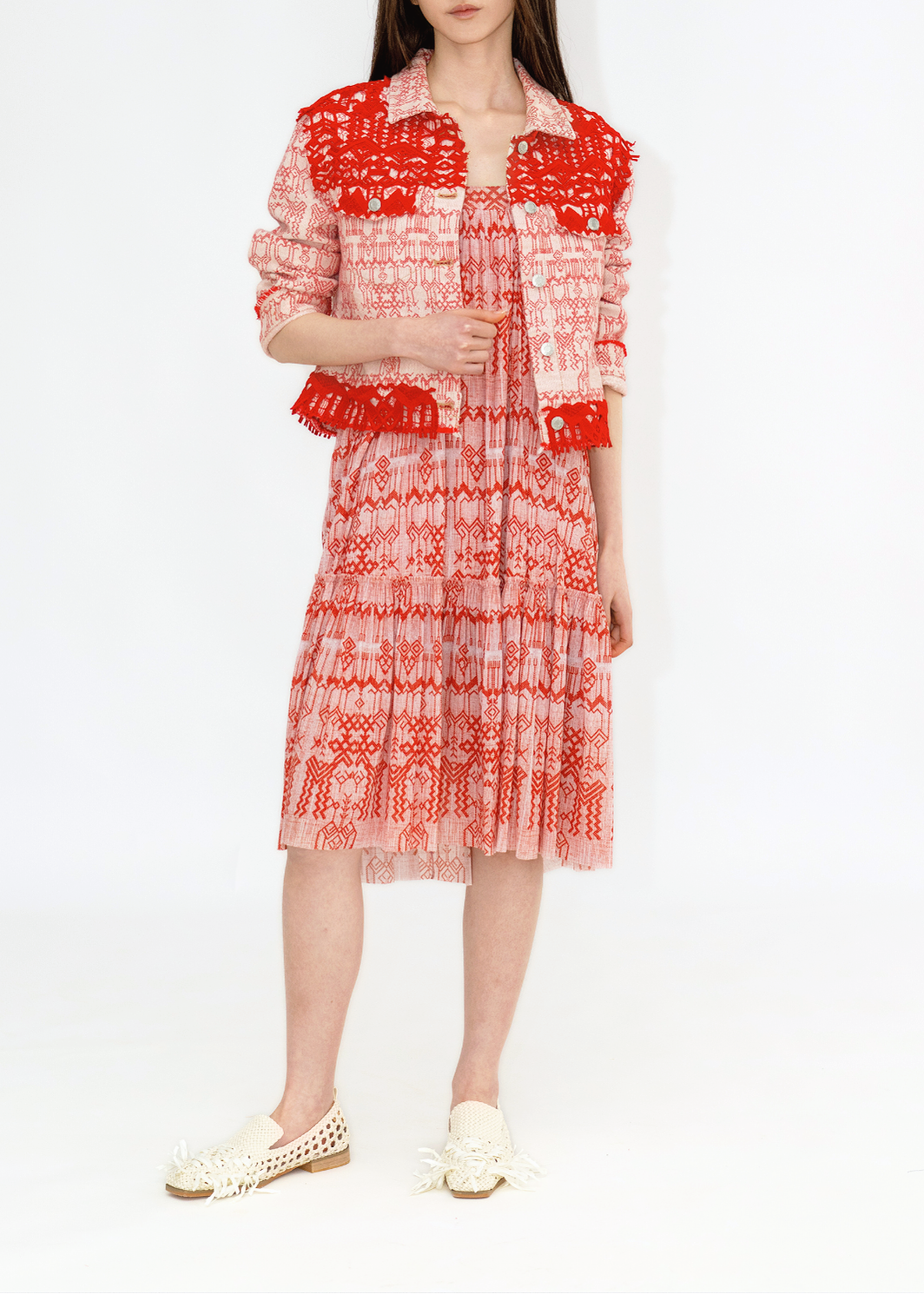 A female model wearing a red and white denim jacket with lace details.