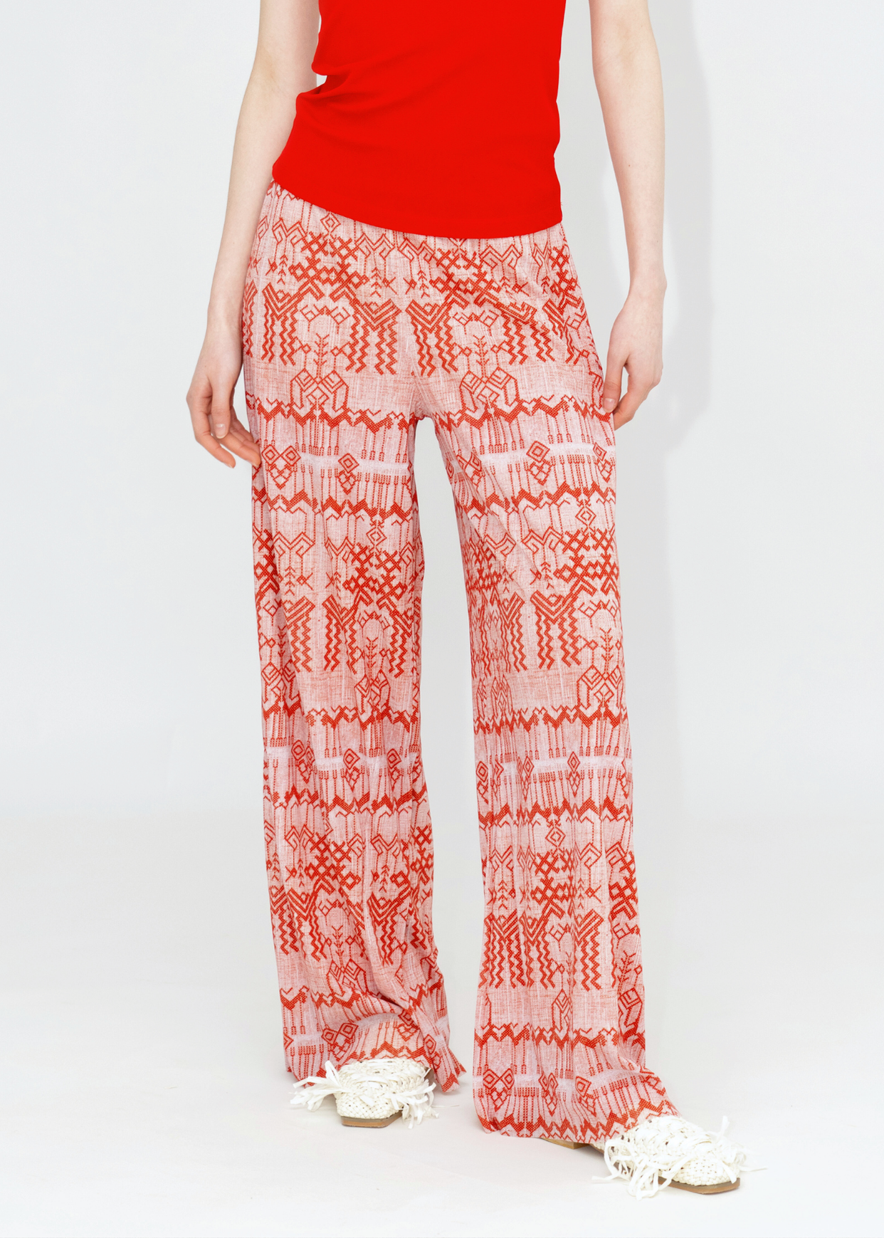 A pair of red and white deer print pants with a netting pattern, likely made from nylon fabric, from the Spring Summer 2025 Collection.