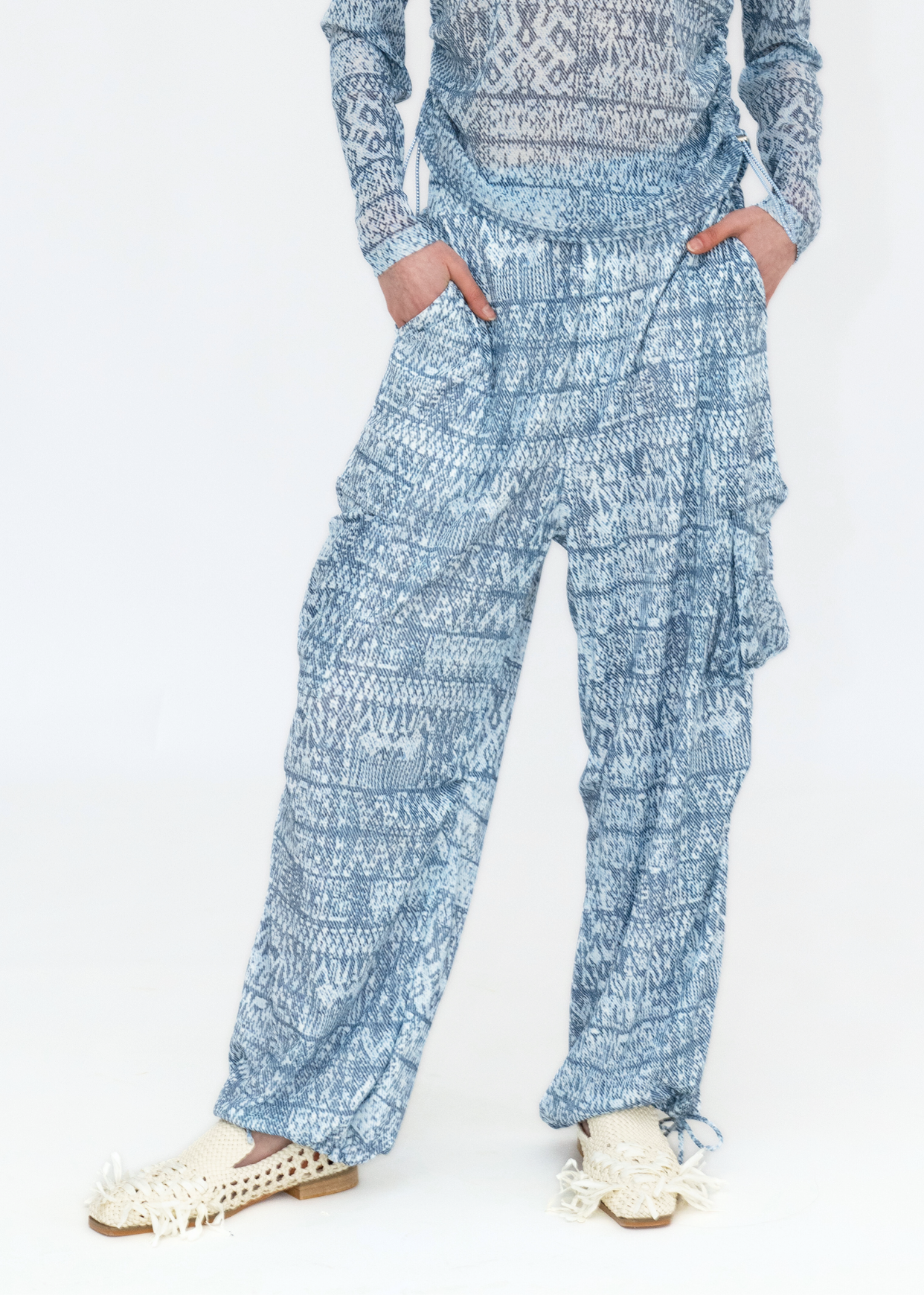 A pair of blue tie-dye stripe print cargo pants with a textured pattern, displayed on a model.