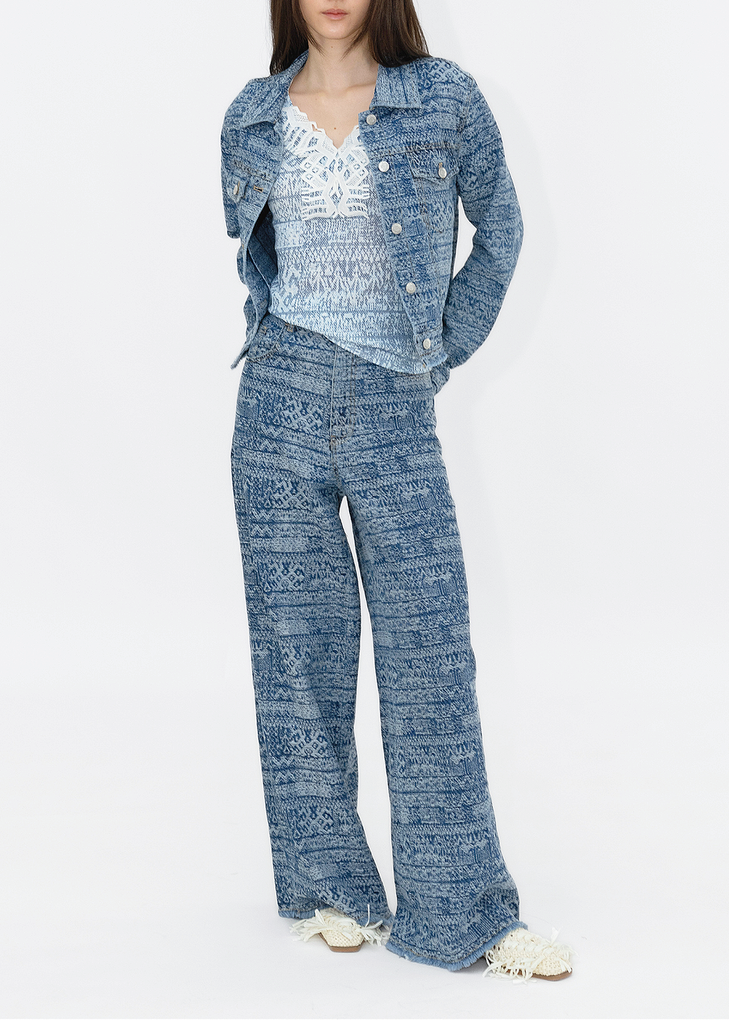 A model wearing a tie-dye stripe print top with deer lace detailing, paired with blue wide-leg pants.