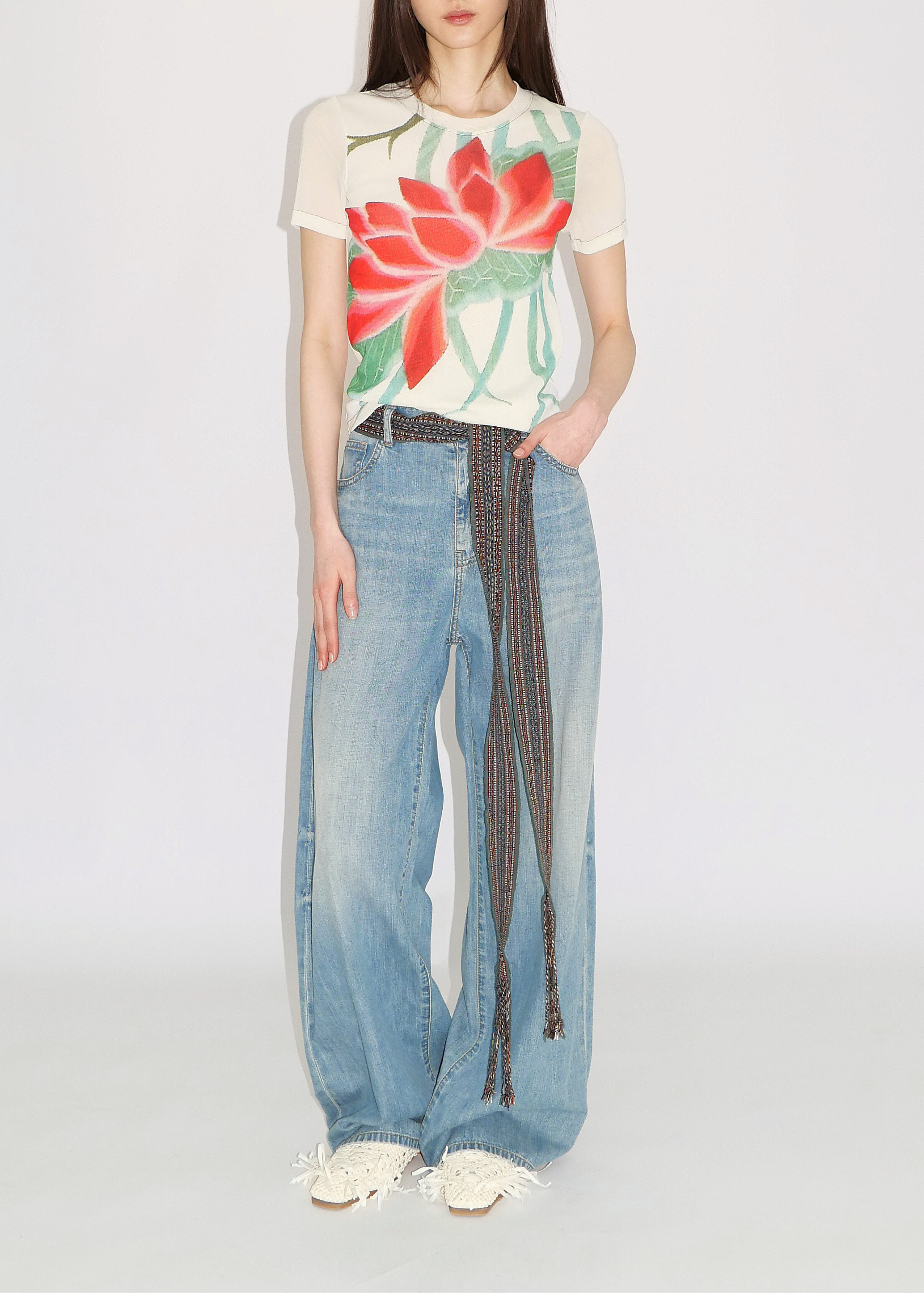 Woman wearing a floral t-shirt and jeans on a white background