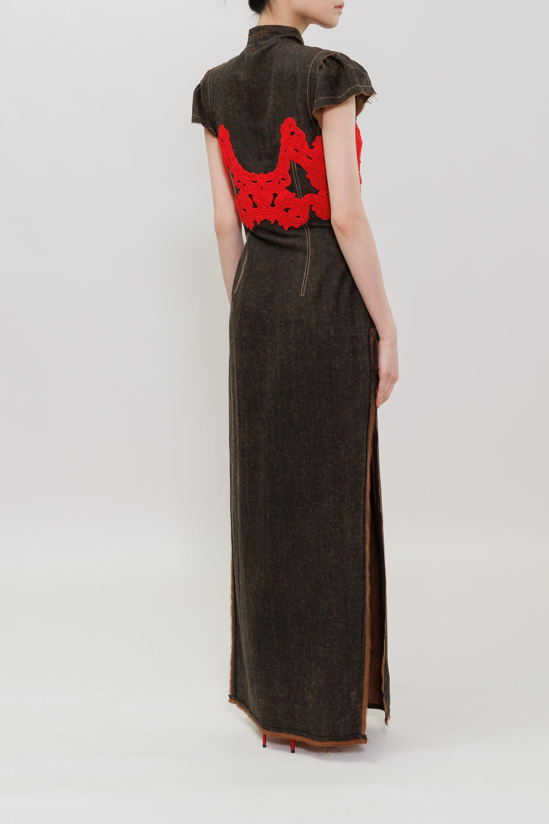 A model is shown from the back wearing a dark brown, high-neck, floor-length cheongsam-style dress with a vibrant red embroidered mountain motif on the back.
