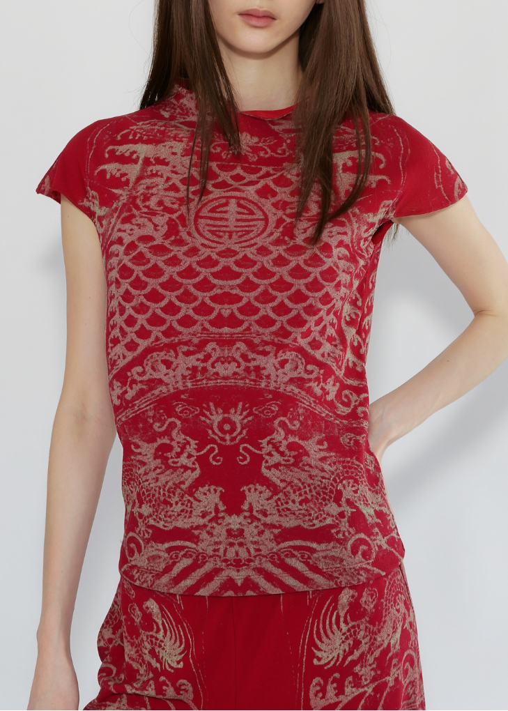 Woman wearing a red dress with intricate patterns on a white background