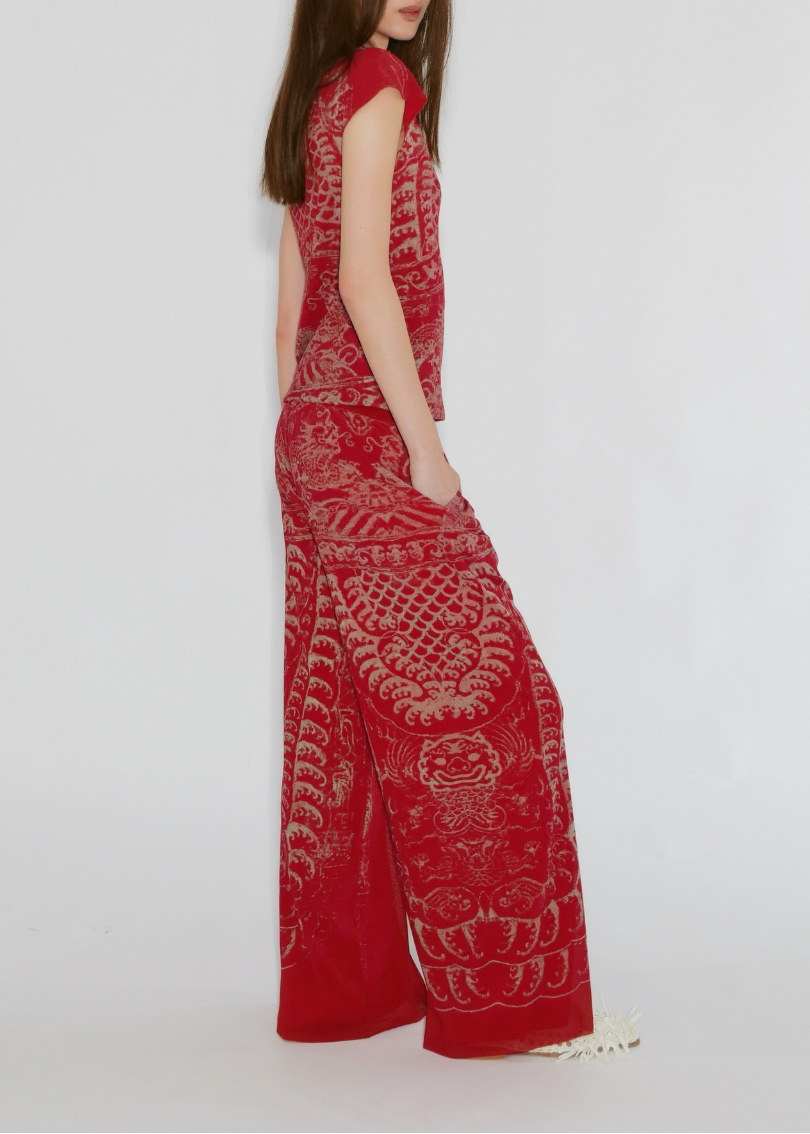 Woman wearing a red patterned dress on a white background