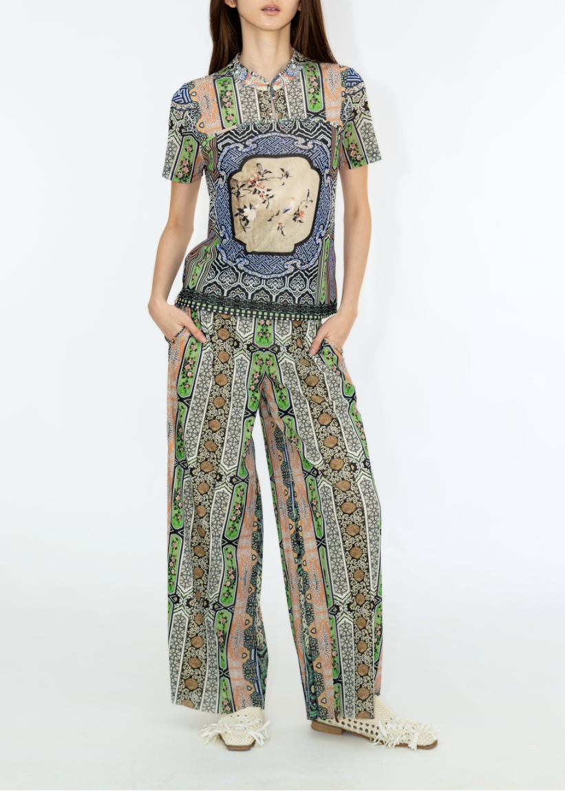 Model wearing a patterned outfit on a white background