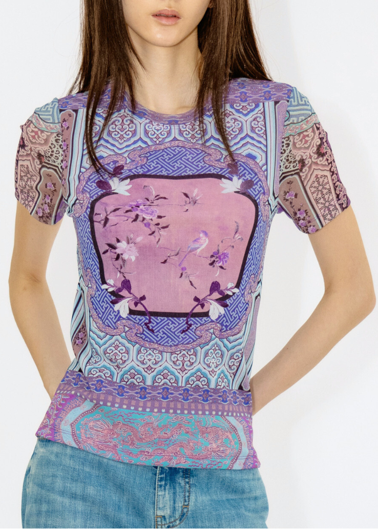 Woman wearing a colorful patterned shirt with a white background