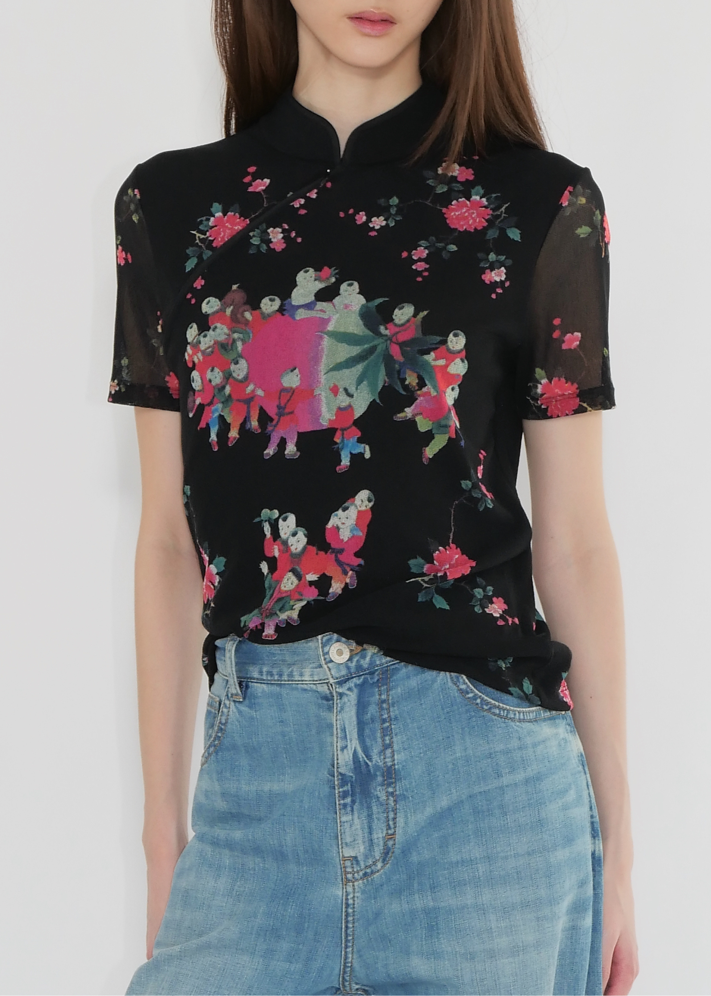Woman wearing a black floral blouse with a plain background