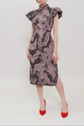 A model wearing a short-sleeved cheongsam-style dress with a dragon print in dusty pink and dark gray, paired with red high heels, against a plain light gray background.