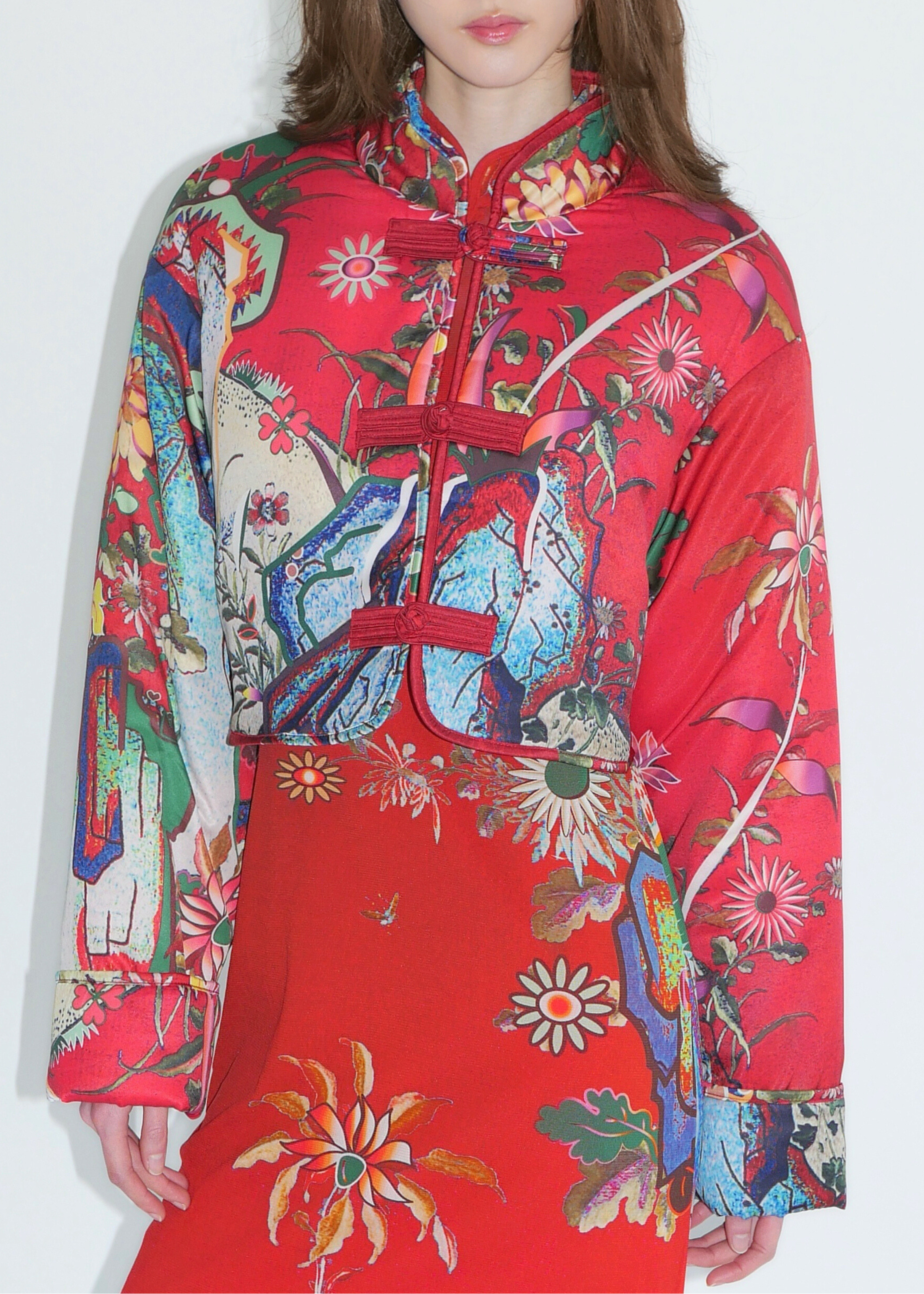 Person wearing a vibrant, multicolored floral dress against a white background